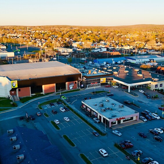 An aerial view of a commercial area with a large building labeled 'EAGLES' and a parking lot filled with cars. 5