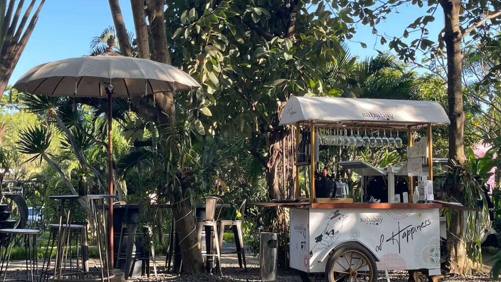 A food cart with a sign reading 'sababay' in a lush, green outdoor setting. 5
