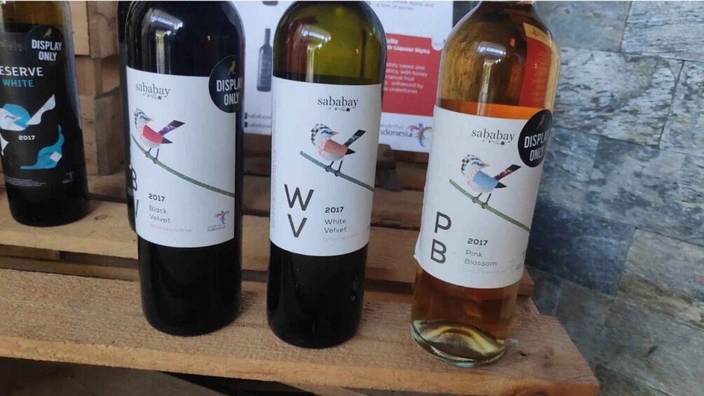 Three bottles of Sababay wine from 2017 on a wooden shelf. 4