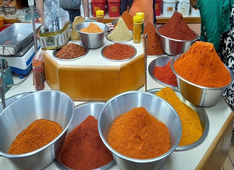A variety of spices displayed in metal bowls on a counter. 2