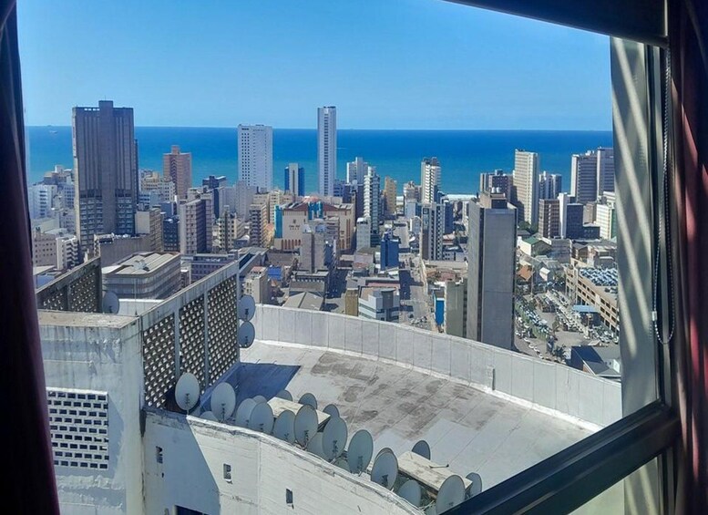 A cityscape with tall buildings and a view of the ocean. 3