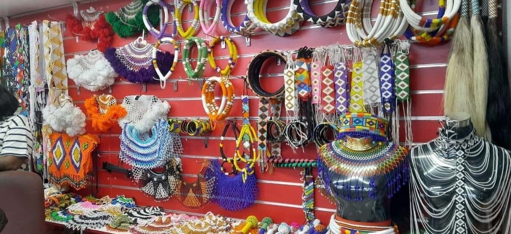 A variety of colorful jewelry displayed on a red wall. 4