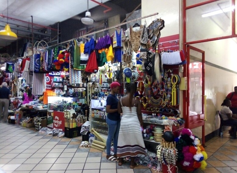 A market with various stalls selling colorful bags, jewelry, and other items. 3