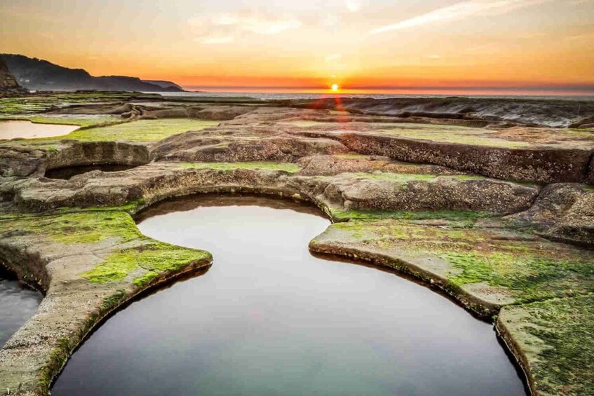 A sunset over a terraced landscape with water features. 2