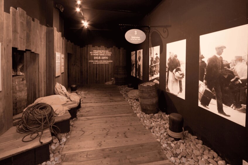 A historical exhibit with wooden walls, a stone pathway, and black-and-white photographs. 3