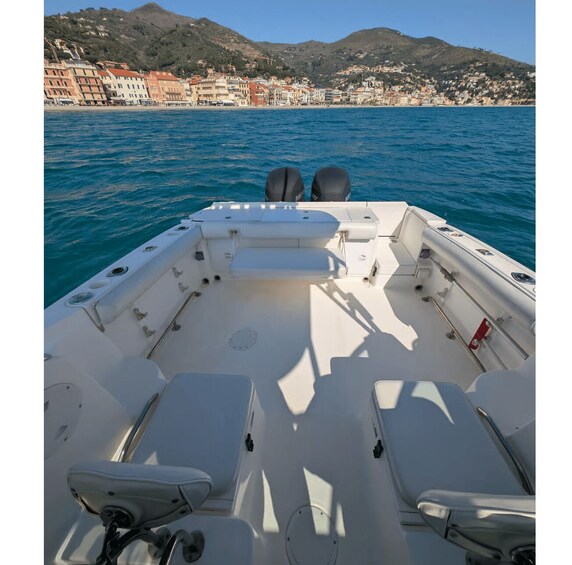 A boat's interior with seating and a view of a coastal town and hills. 3