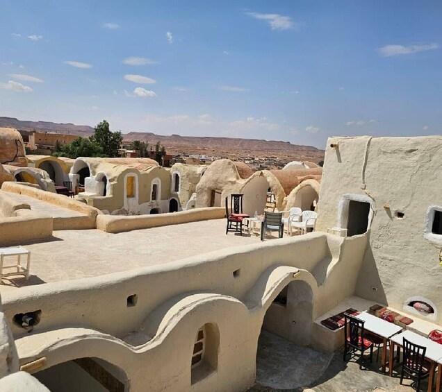 Traditional mud-brick buildings with arched doorways and outdoor seating areas. 3