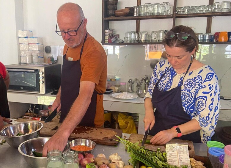 Two people preparing food in a kitchen with various ingredients and utensils. 2