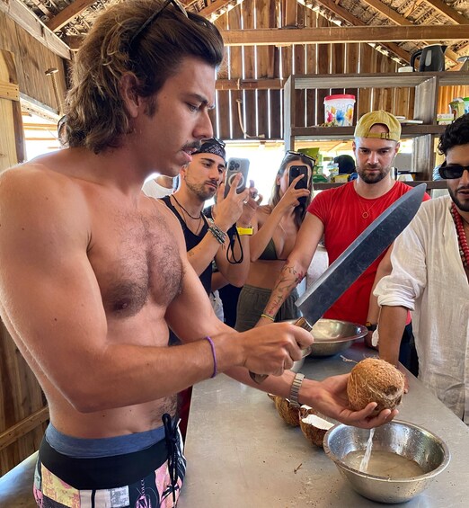 A person preparing food with a knife and coconut. 3