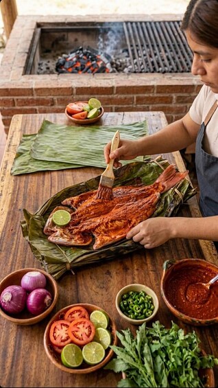 A person grilling a whole fish on a wooden table with lime, tomatoes, and chili peppers nearby. 1