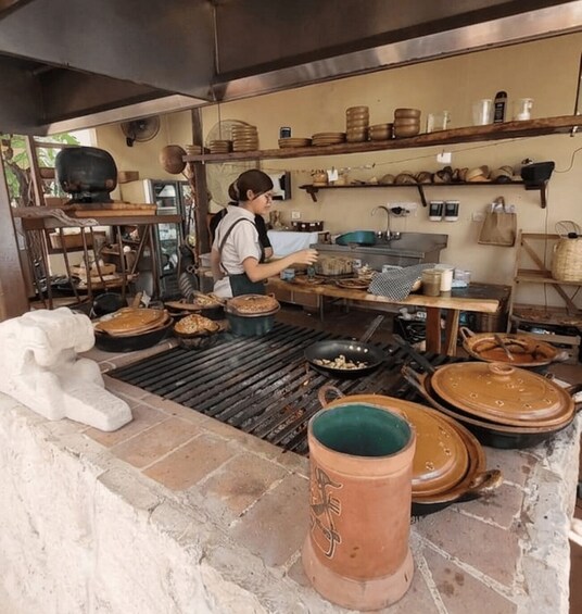 A rustic kitchen with a chef preparing food, surrounded by traditional cookware and utensils. 4