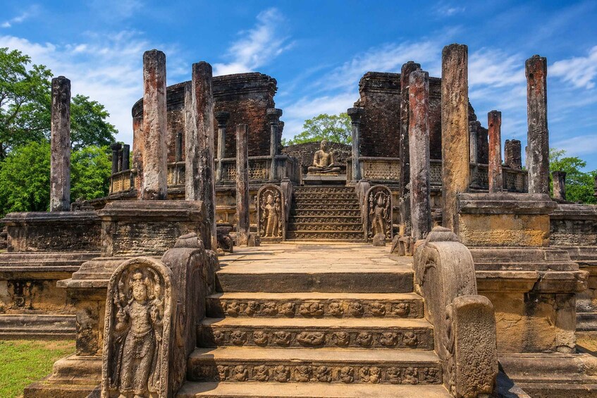 Ancient stone ruins with a central staircase leading to a seated figure. 3