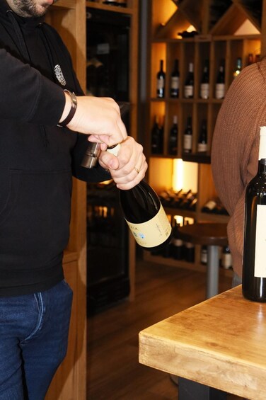 A person opening a bottle of wine. 2