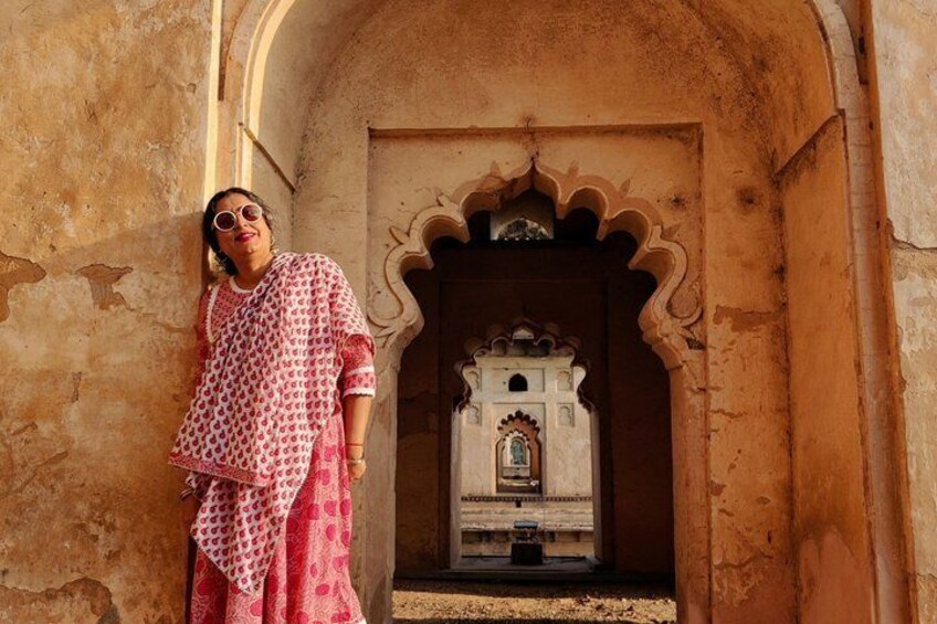 A person standing in front of a traditional archway with intricate carvings. 1