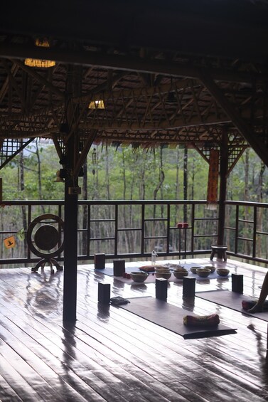 A wooden deck with a railing, surrounded by trees. 4