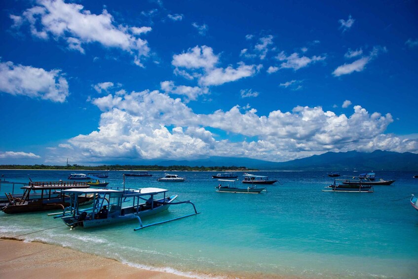 A clear blue sky, calm turquoise waters, and several boats anchored near the shore. 5