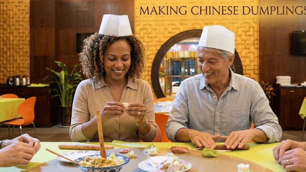 Two people making Chinese dumplings at a restaurant. 2
