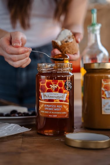 A person spreading honey on bread. 5