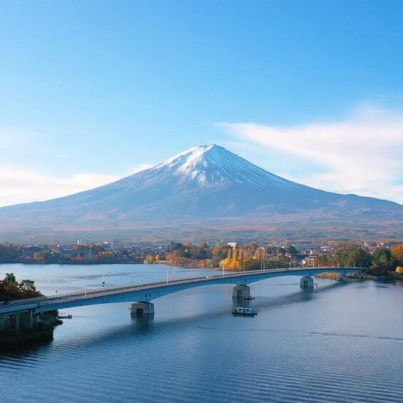 A bridge over a body of water with a mountain in the background. 1
