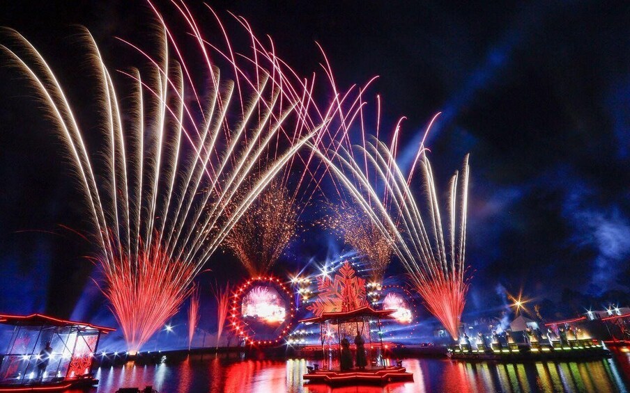 Fireworks over water with a Ferris wheel in the background. 1