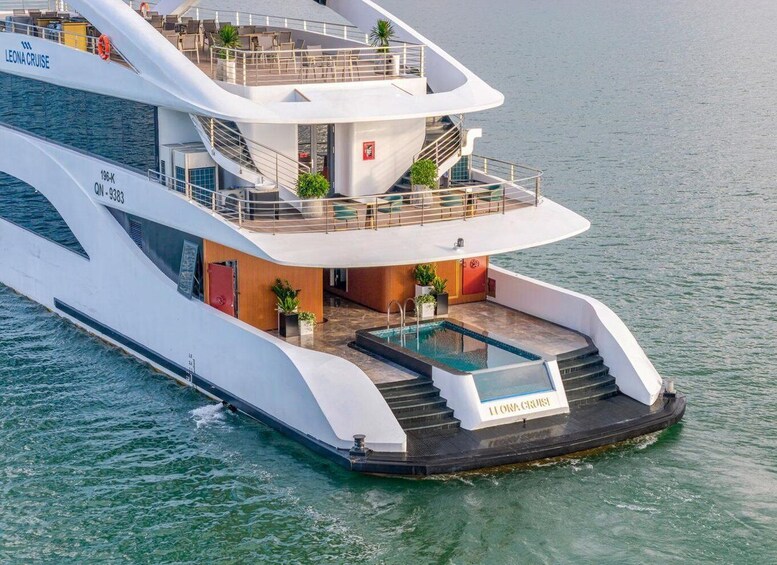 A large, modern yacht with multiple decks and a swimming pool. 1