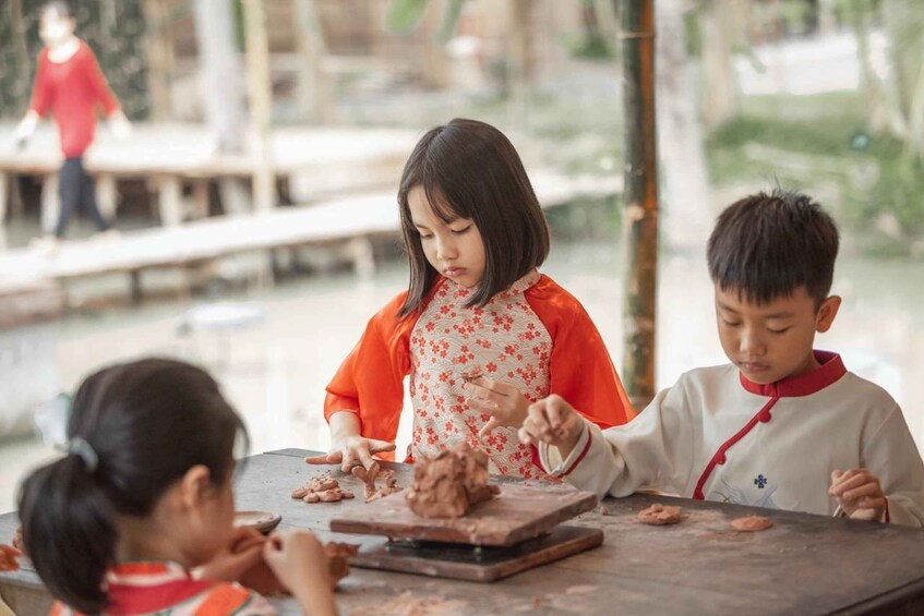 Children playing with dough at an outdoor table. 3
