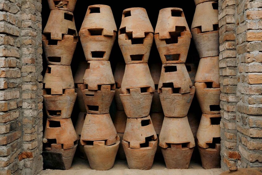 A stack of terracotta pots in a brick structure. 4