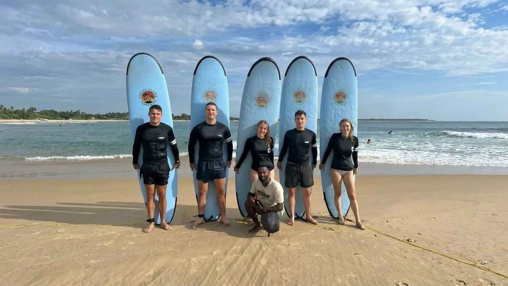 A group of people on a beach with surfboards. 2