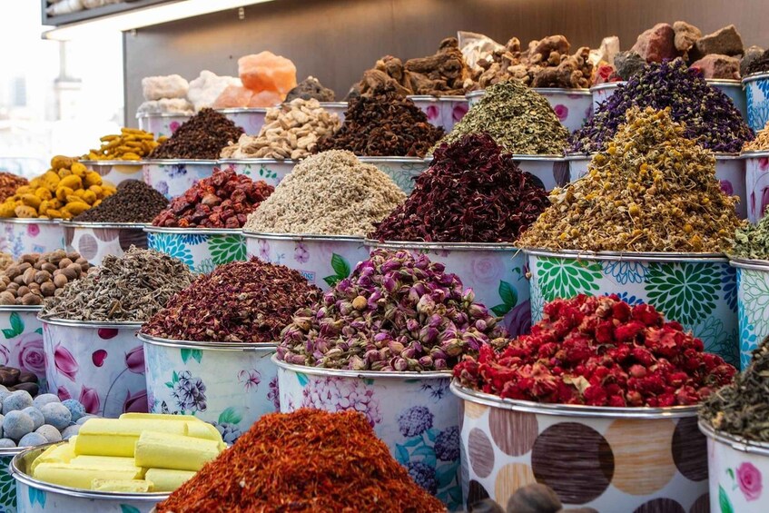 A variety of spices and dried herbs displayed in colorful containers. 5
