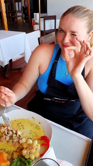 Une personne assise à une table devant un bol de soupe. 3