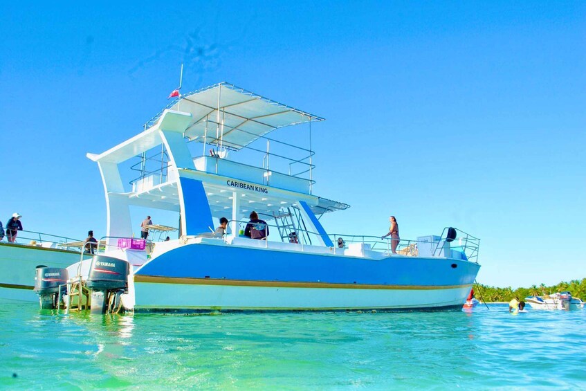 A blue and white boat named 'Caribbean King' with people on deck and another boat nearby. 3