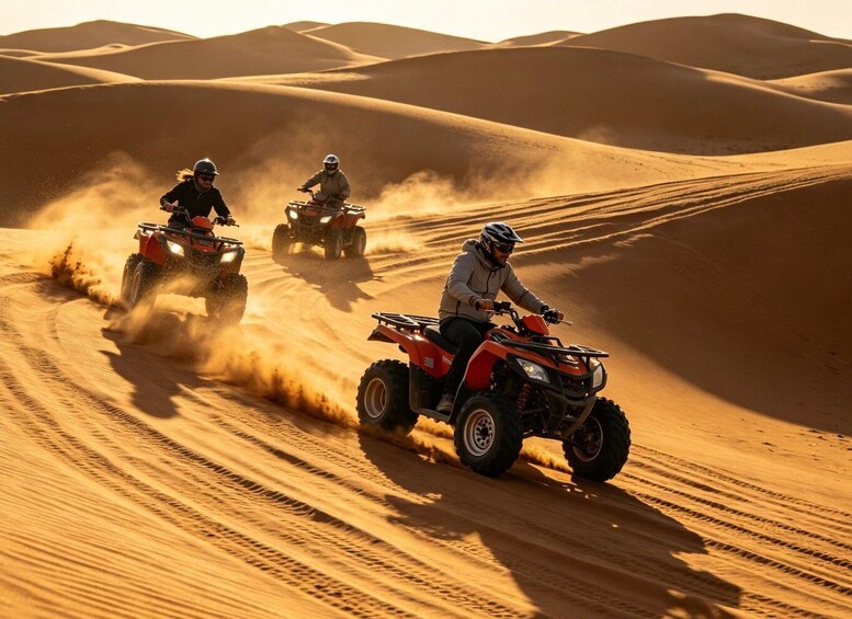 Three people riding ATVs on a sandy dune. 5