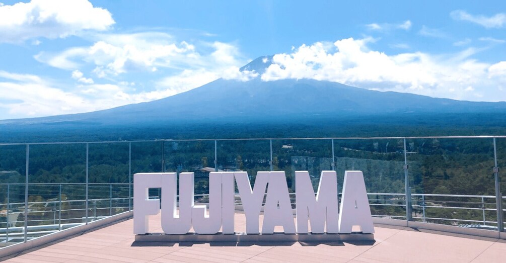 A sign with 'FIJIYAMA' in large letters, a mountain in the background, and a clear sky. 3