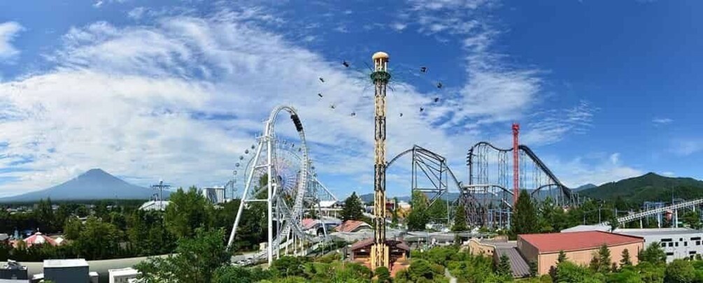 A roller coaster with a tall central tower, a mountain in the background, and a clear blue sky. 1