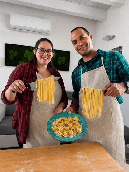 Two people making pasta in a kitchen. 5