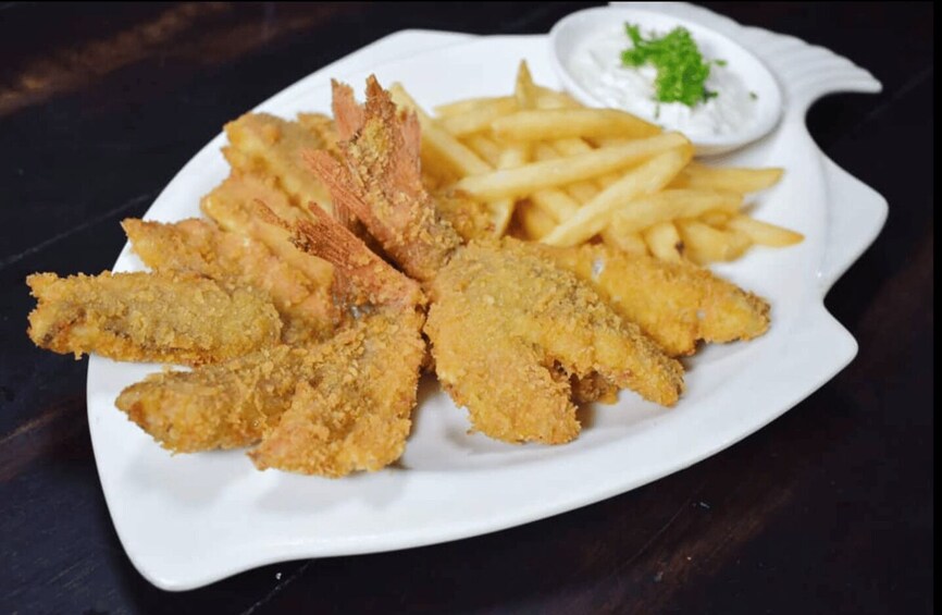 A plate of breaded and fried fish fillets, French fries, and a side of tartar sauce. 1