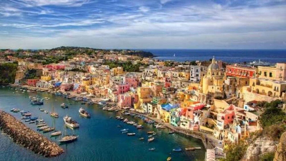 A coastal town with colorful buildings, a harbor with boats, and a clear blue sky. 3