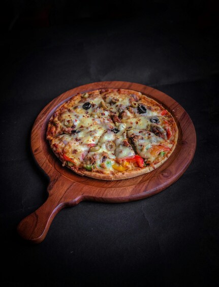 A pizza on a wooden board. 4