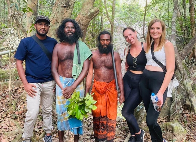 A group of people in a forested area with trees and foliage. 1