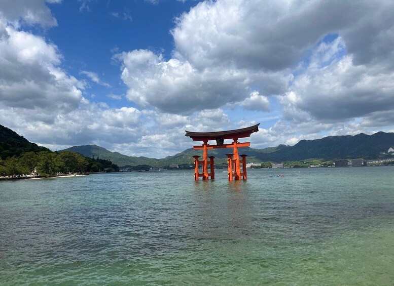 A traditional Japanese torii gate over a calm lake with mountains in the background. 3