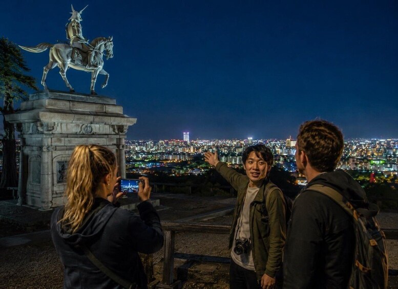A nighttime cityscape with a statue of a figure on horseback. 1