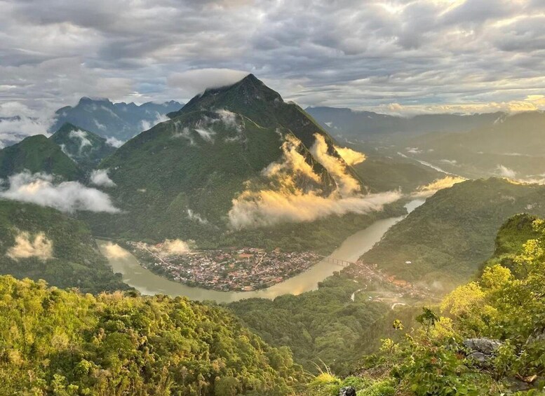 A mountainous landscape with a river, a town, and a bridge. 5
