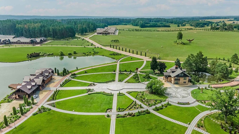A golf course with a central pond, surrounded by manicured lawns and a variety of buildings. 2