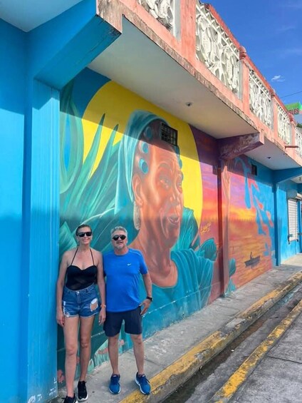 A mural on a building with a blue wall and a colorful sunset design. 5