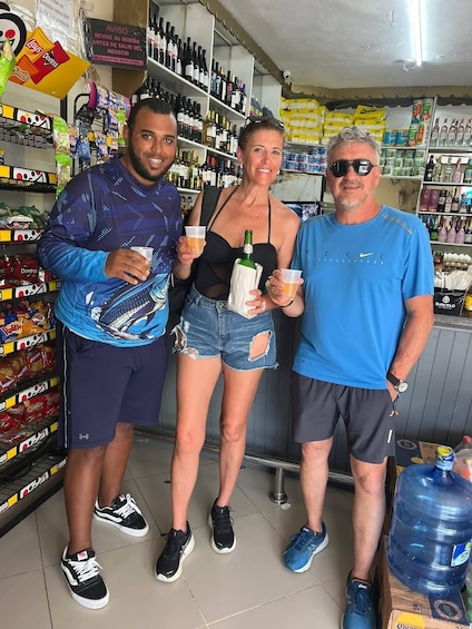 Three people in a store with shelves of snacks and bottles. 4