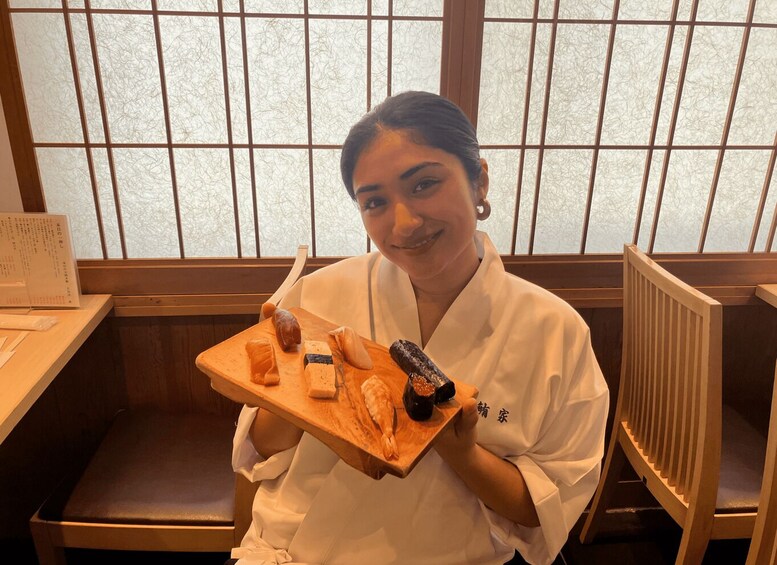 A person in a white uniform holding a tray with various food items. 3