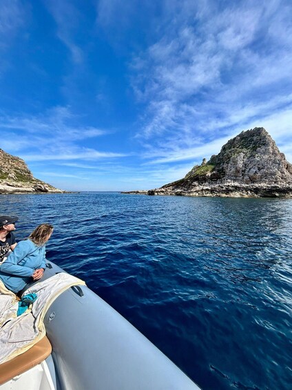 A boat on a calm sea with rocky cliffs in the distance. 3