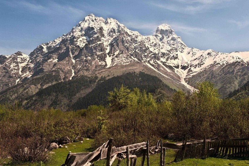 A snow-capped mountain range with a wooden fence in the foreground. 5