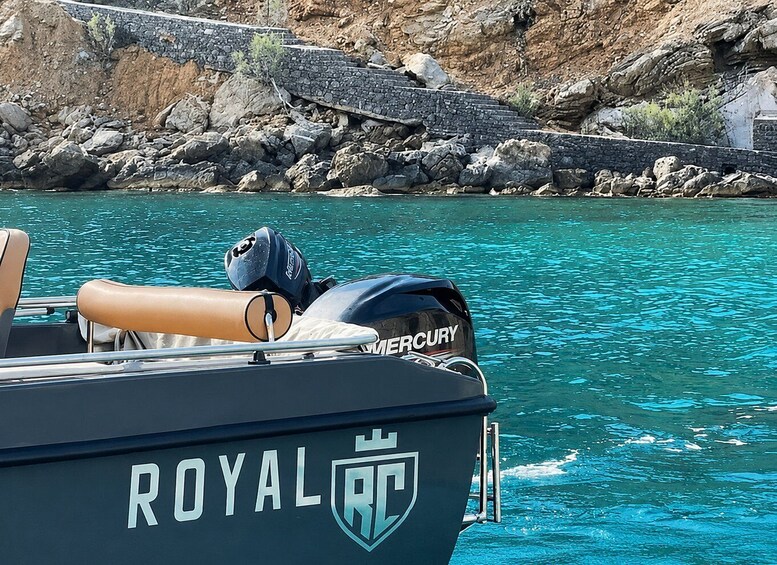 A boat named 'ROYAL RC' with a Mercury outboard motor, calm turquoise water, and rocky cliffs in the background. 2