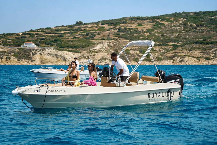 A white boat with 'ROYAL CRUISES' on the side, people on board, and a rocky coastline in the background. 4